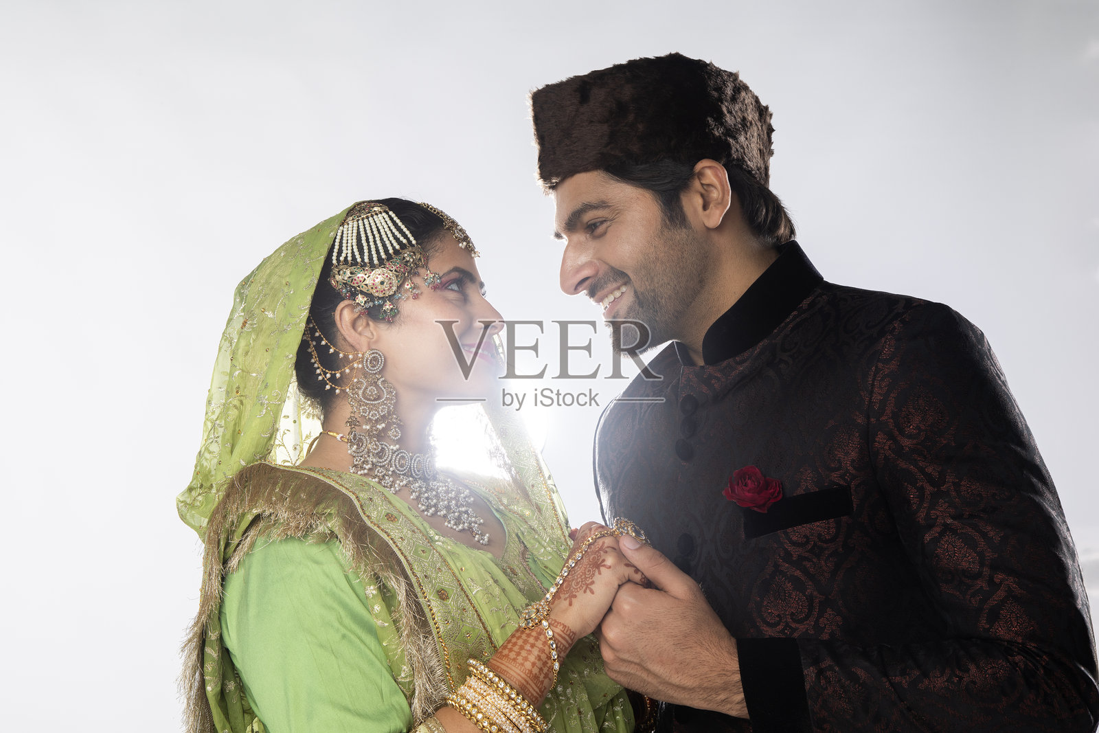 新婚夫妇在白色背景下牵手照片摄影图片