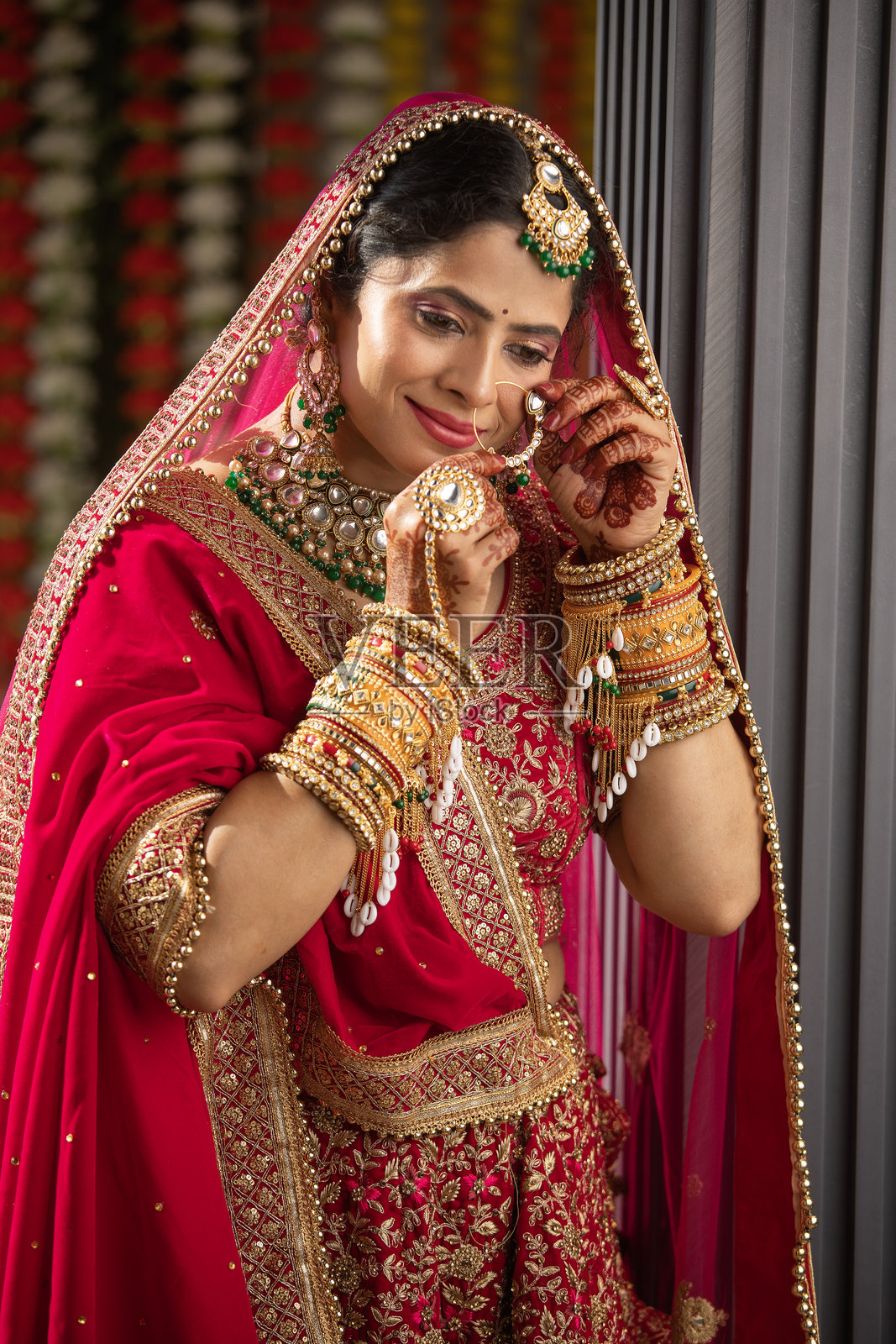 美丽微笑的新娘穿着传统服装，正在调整她的鼻环照片摄影图片