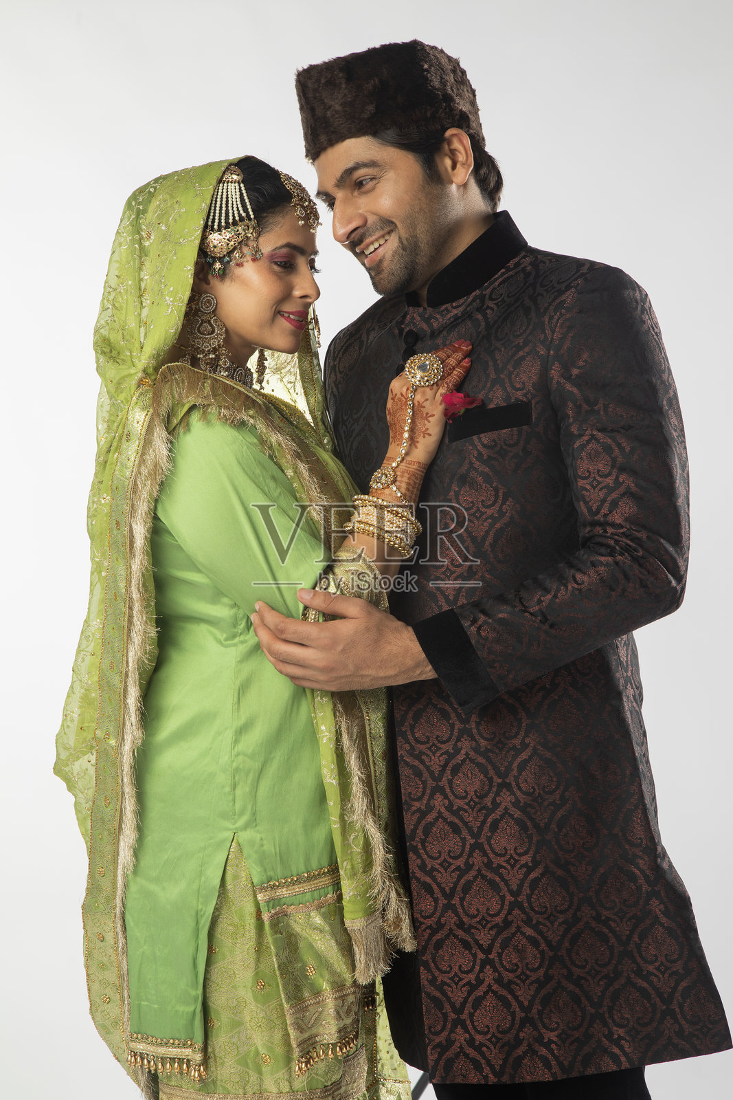 身穿传统服装的浪漫新娘和新郎的肖像，背景为白色。照片摄影图片