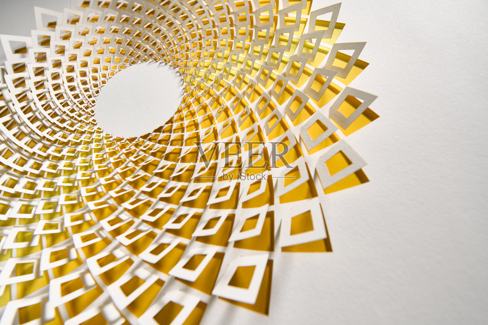 复杂的几何剪纸艺术作品，带有圆形图案和鲜艳的黄色点缀，背景为白色照片摄影图片