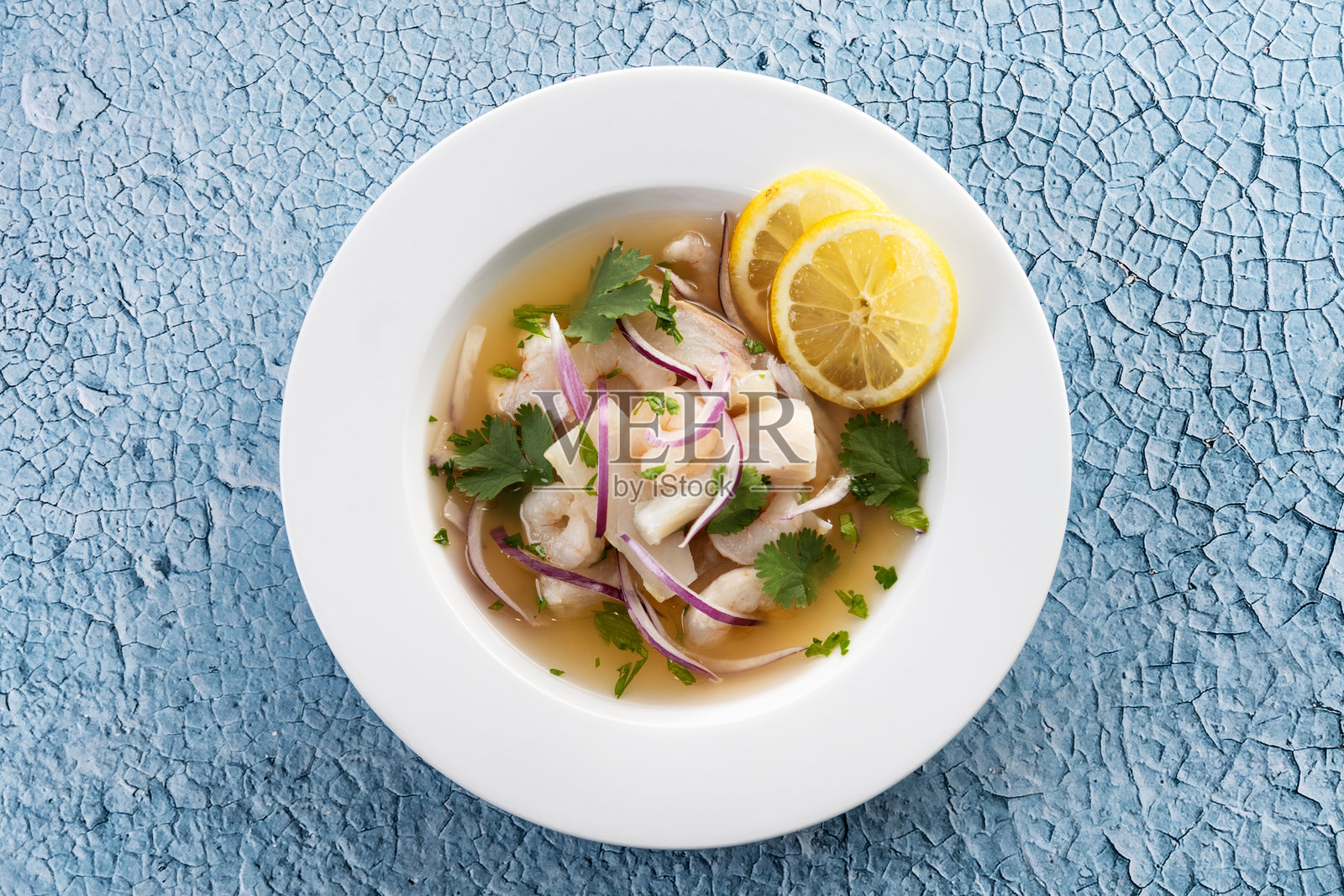 传统秘鲁酸橘汁腌鱼海鲈鱼片，背景为蓝色照片摄影图片