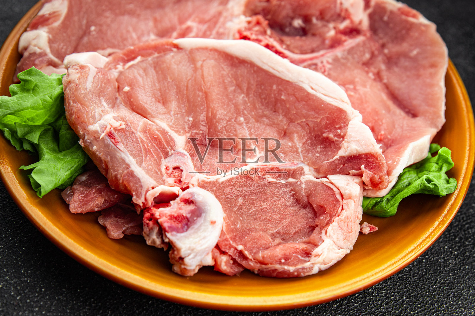 新鲜美味的生猪肉骨头，精致的美食背景， rustic 风格的桌面俯视图，留白空间。照片摄影图片