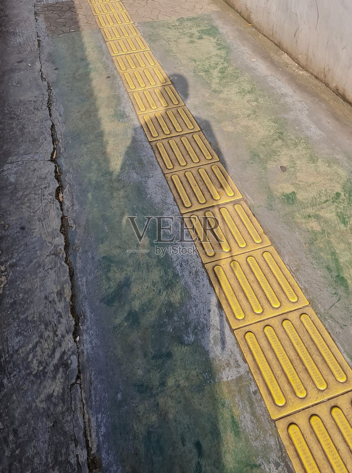 巷子里的黄色触觉砖是盲人的行走指引。照片摄影图片