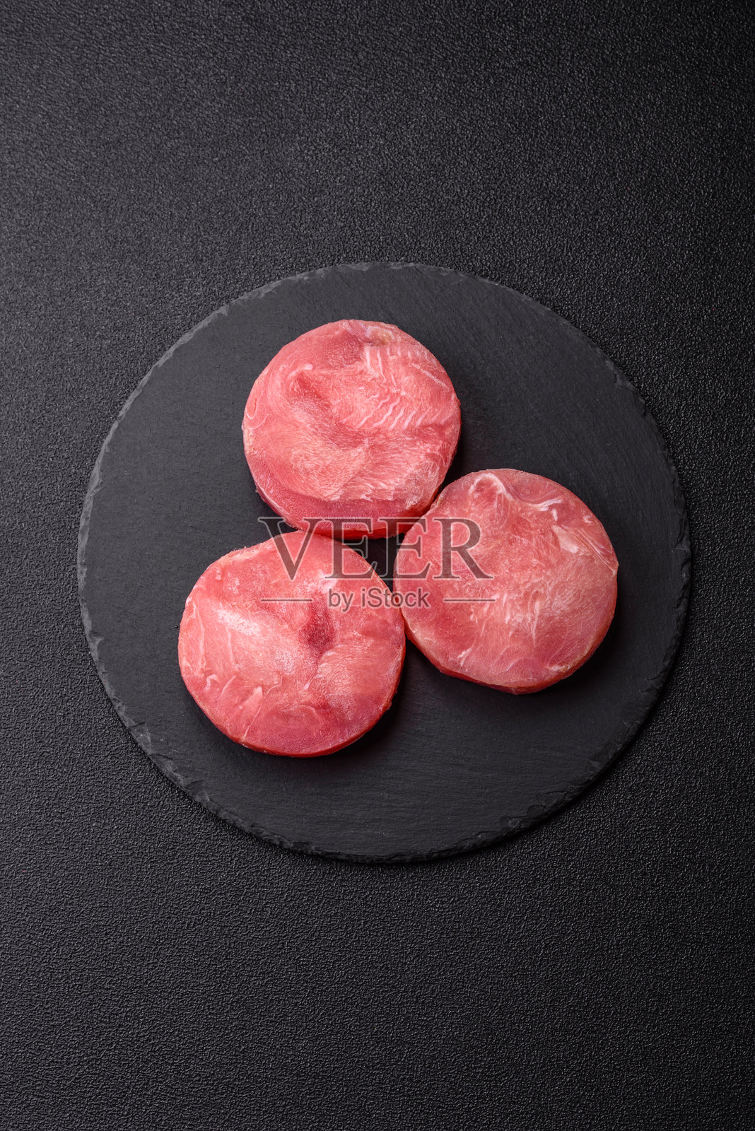 两片新鲜的生金枪鱼片，配以香料和草药照片摄影图片