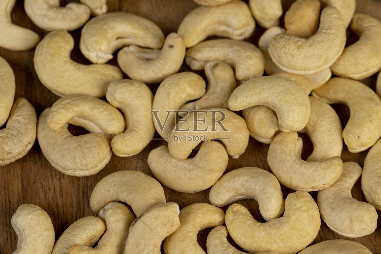 大腰果散落在落叶松木板上照片摄影图片