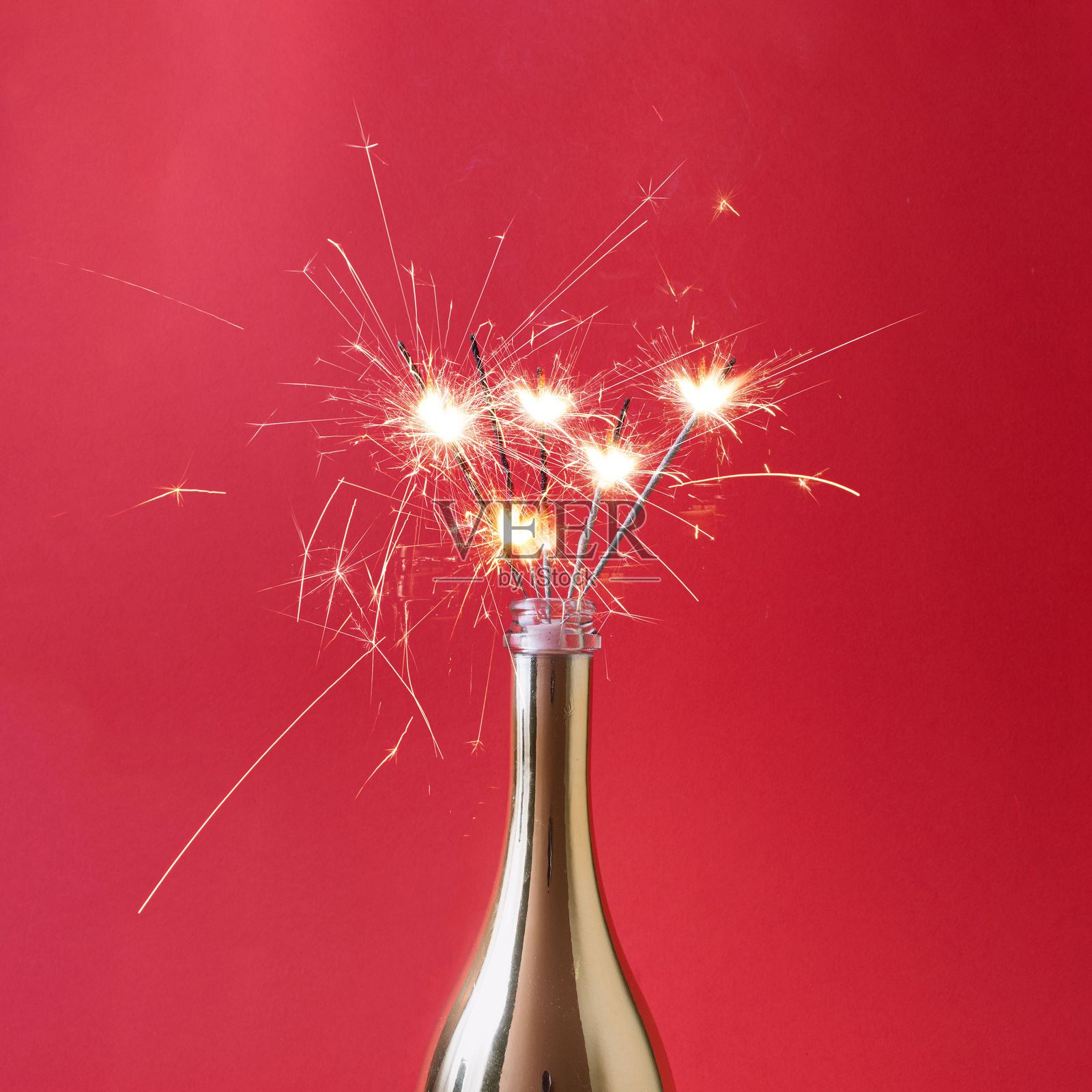 红色背景上的香槟瓶与烟花。照片摄影图片