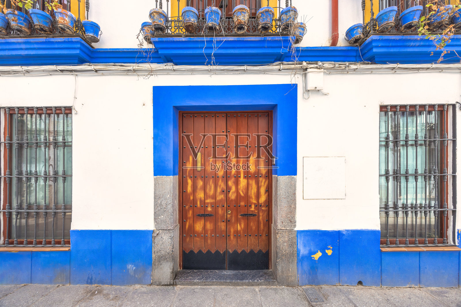 西班牙科尔多瓦镇。传统建筑外立面，蓝色装饰，木门和铁窗格。经典的建筑细节。照片摄影图片