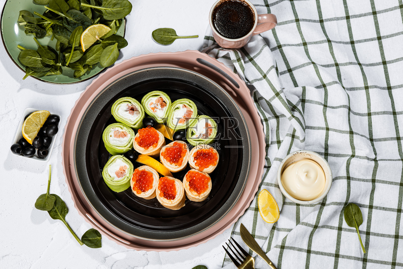 绿色煎饼卷配费城奶酪、红鱼、红鱼子、柠檬、橄榄、鱼子酱煎饼、菠菜、平铺、马斯连尼察、日本卷、奶油奶酪与三文鱼、静物照片摄影图片