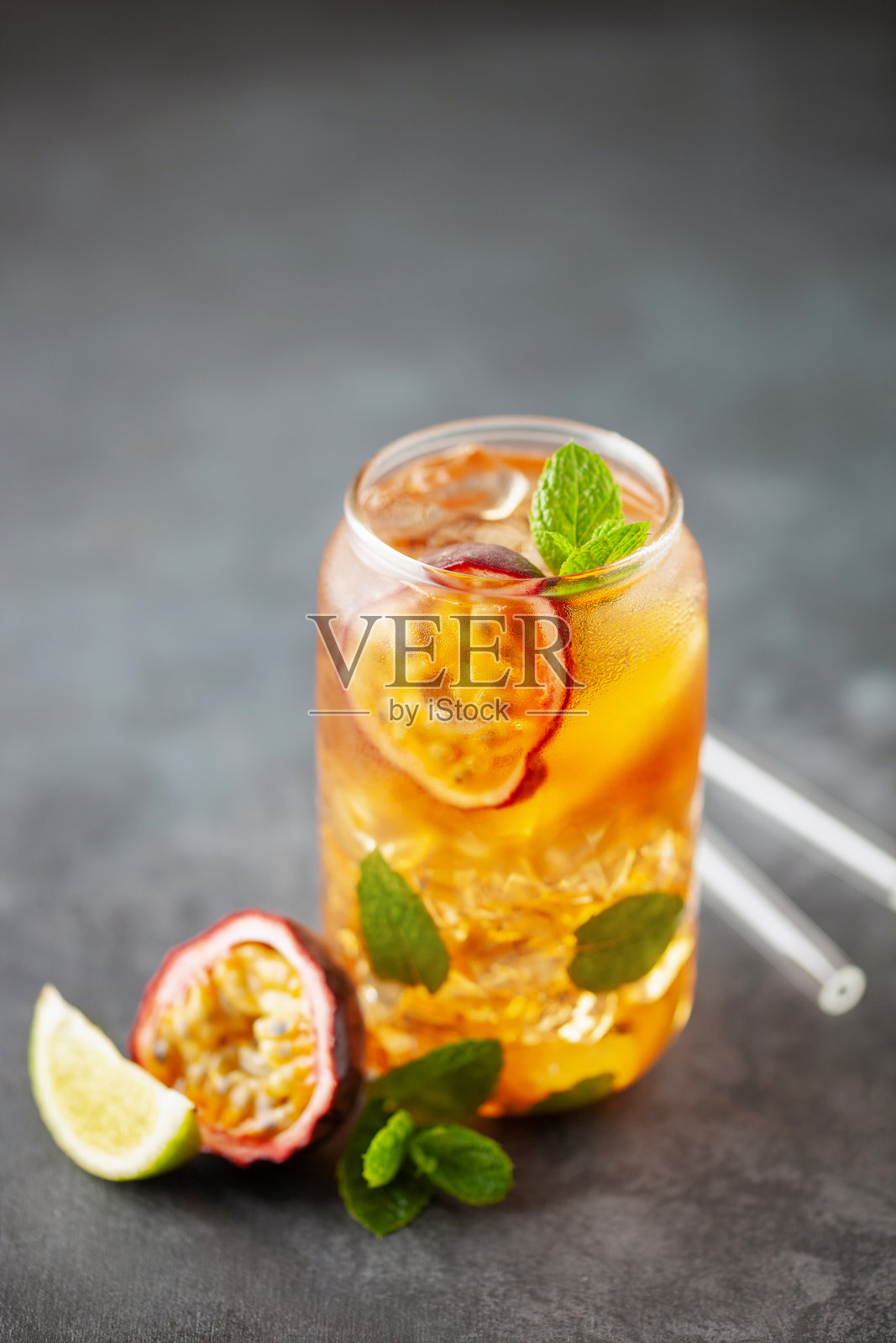 水果冰茶。清爽的夏季饮品，含有糖浆、百香果、青柠、薄荷和冰块。杯中盛满冷饮和健康饮品。照片摄影图片