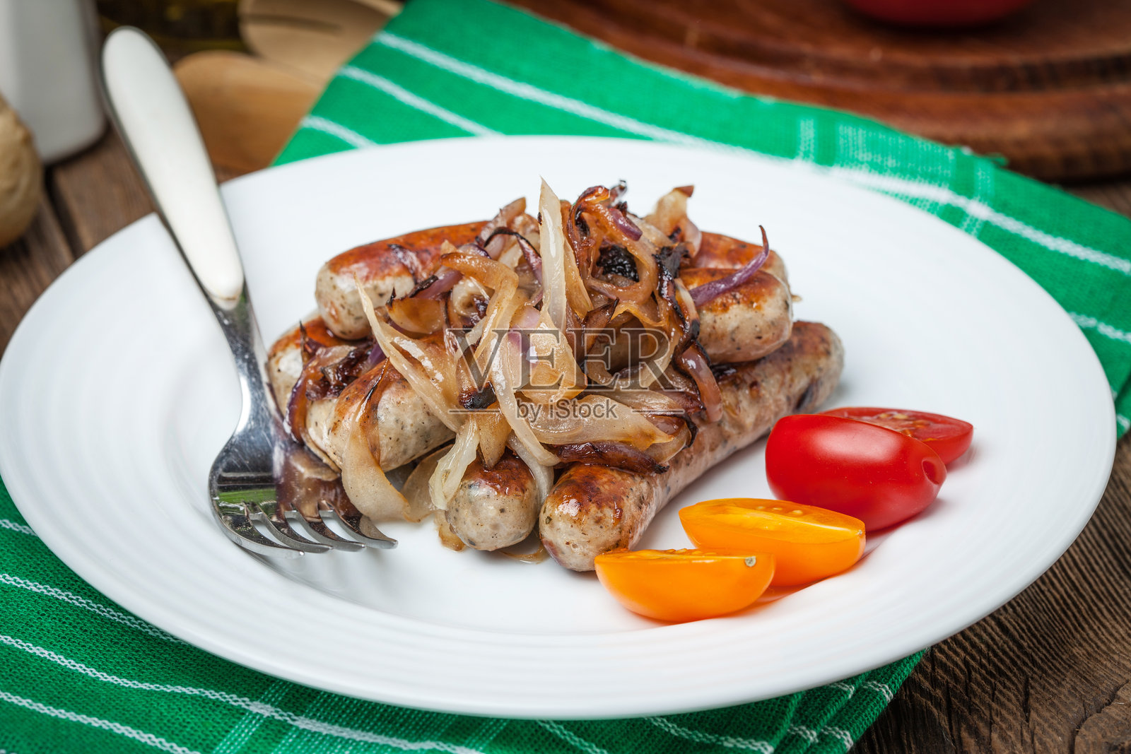 盘子上的炸白香肠和洋葱。照片摄影图片