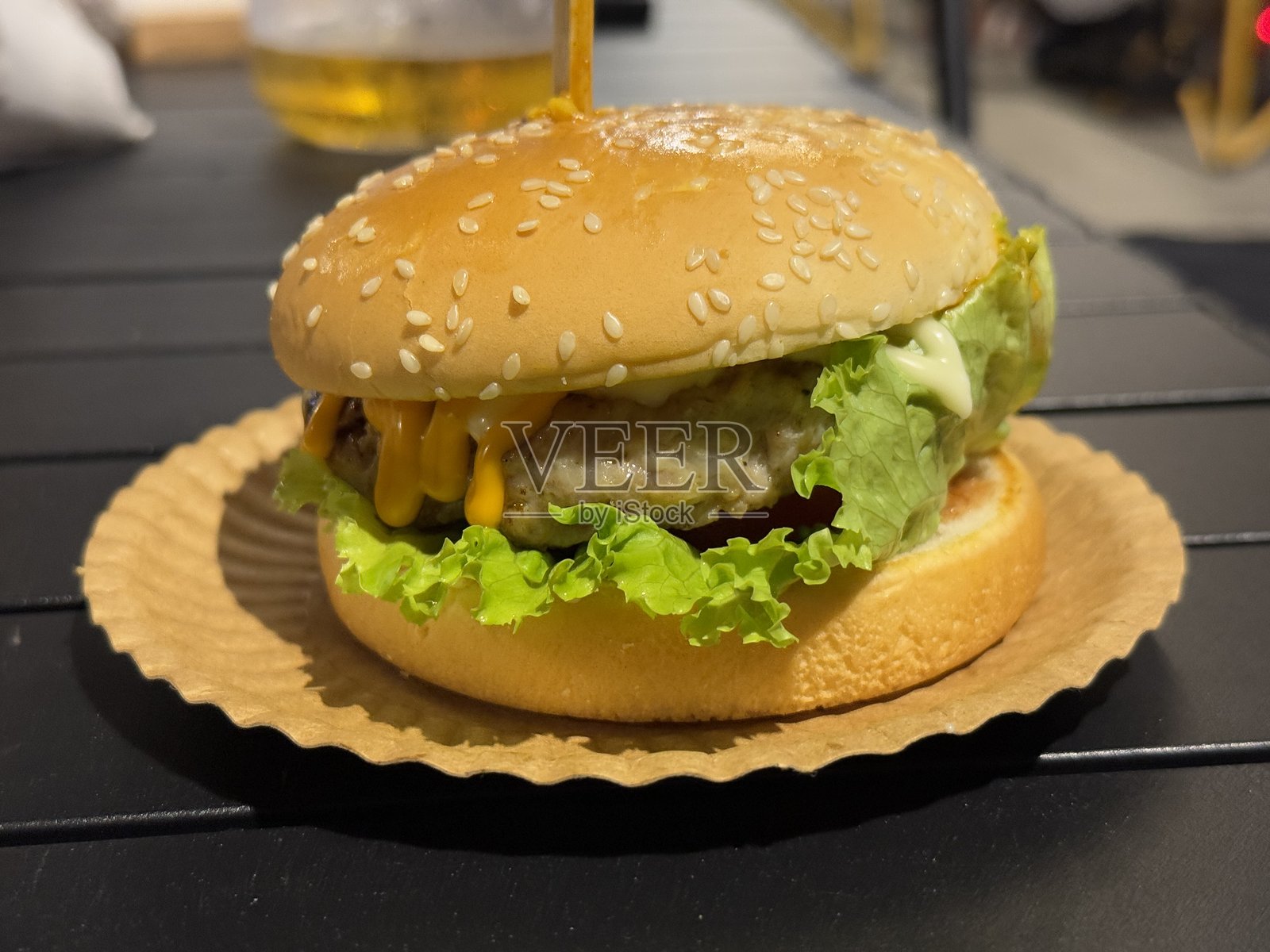木桌上的汉堡，夹着奶酪和生菜，特写镜头照片摄影图片