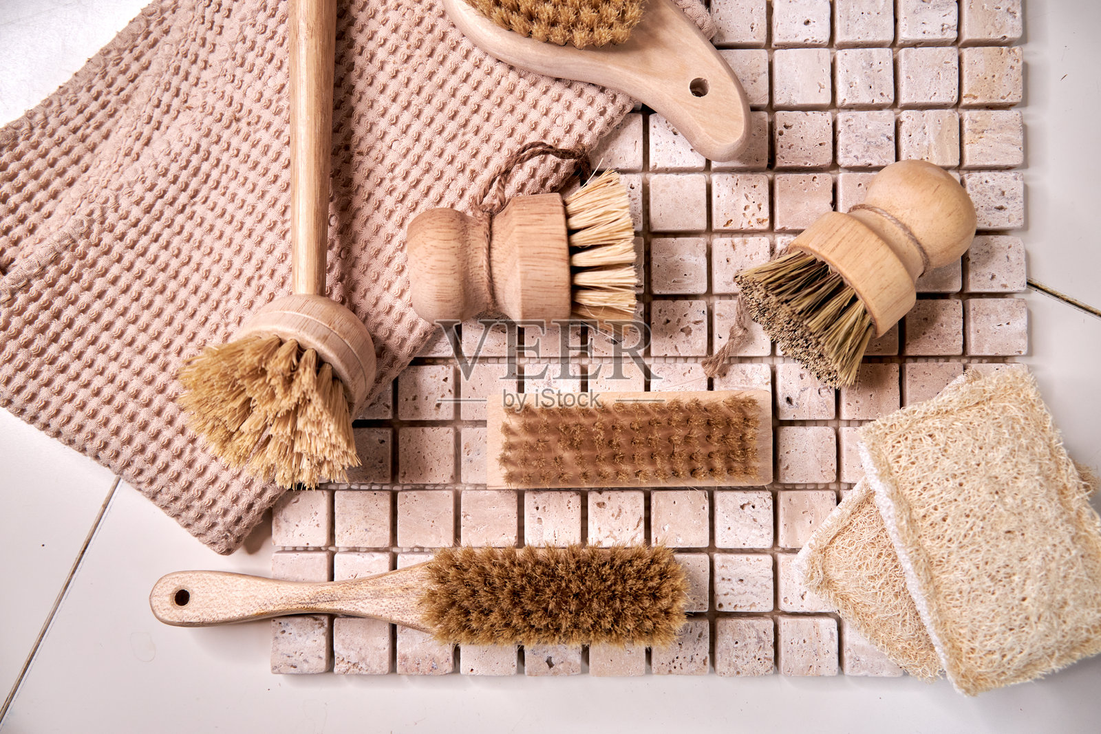 各种木制餐具和清洁刷放在瓷砖台面上，俯视的特写镜头照片摄影图片