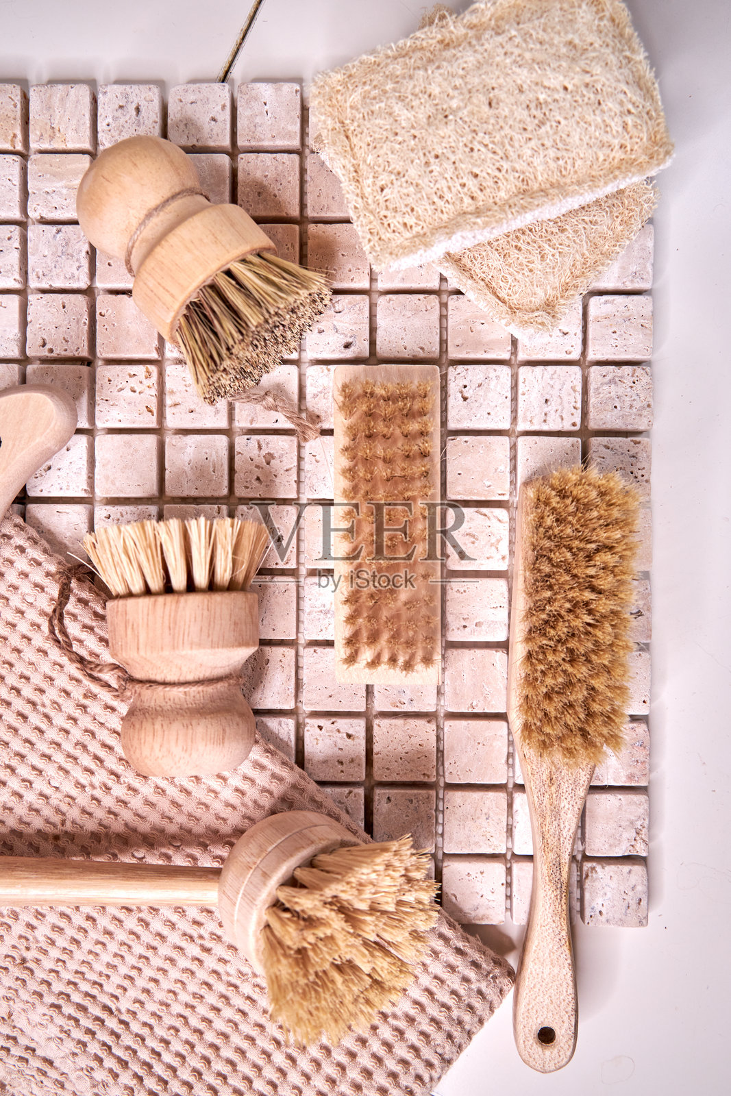 各种木制餐具和清洁刷静静地放在瓷砖台面上，俯视的特写镜头照片摄影图片