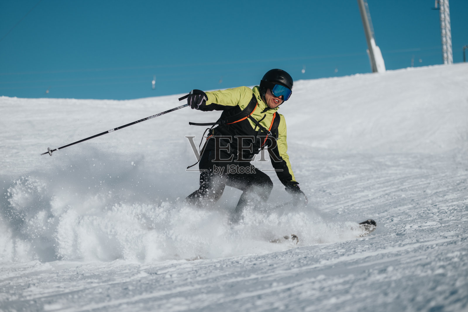 运动员在阳光明媚的天气中滑雪，享受休闲冬季运动。照片摄影图片