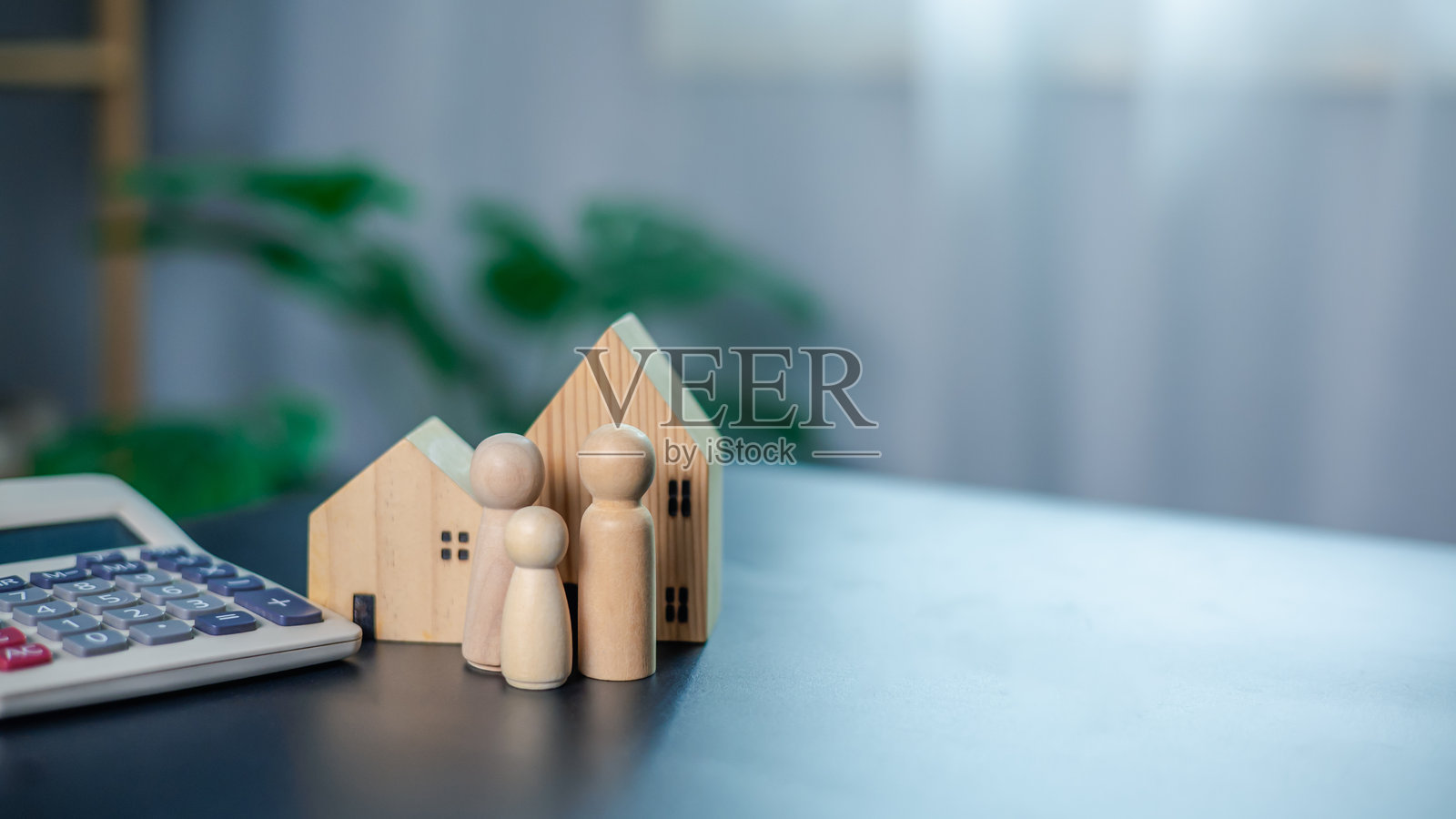 房地产、家庭、房屋模型和旁边的计算器强调了房地产和财务规划，清晰地代表了银行业务、储蓄和投资，以确保未来资产的安全。照片摄影图片
