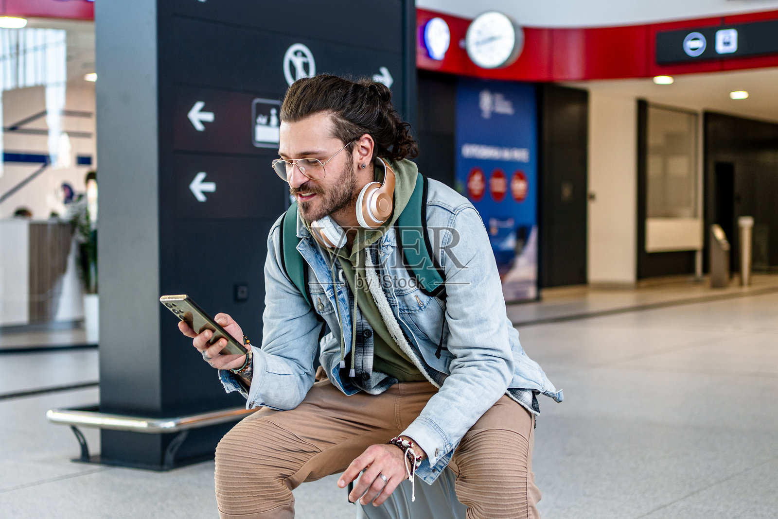 年轻男旅客在火车站使用手机照片摄影图片