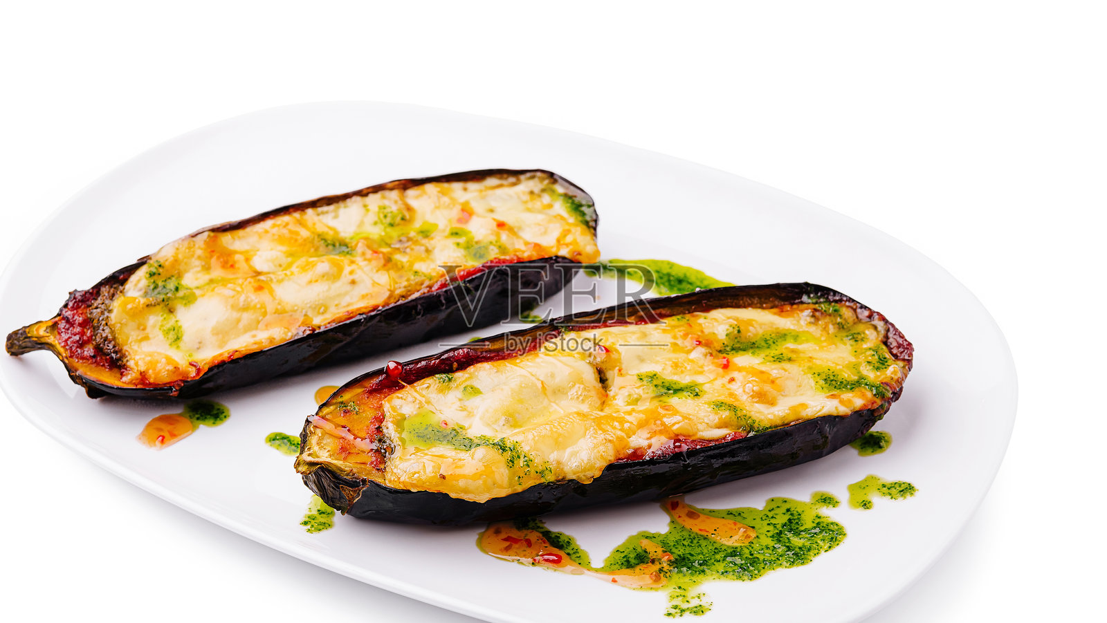 美味的奶酪和绿色酱料填充的茄子，盛放在白色盘子上照片摄影图片