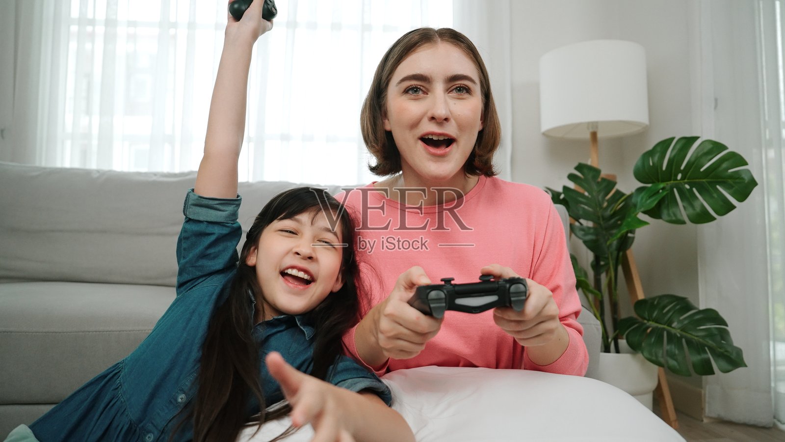 白人母亲和女儿坐在客厅里玩游戏。教育学。照片摄影图片