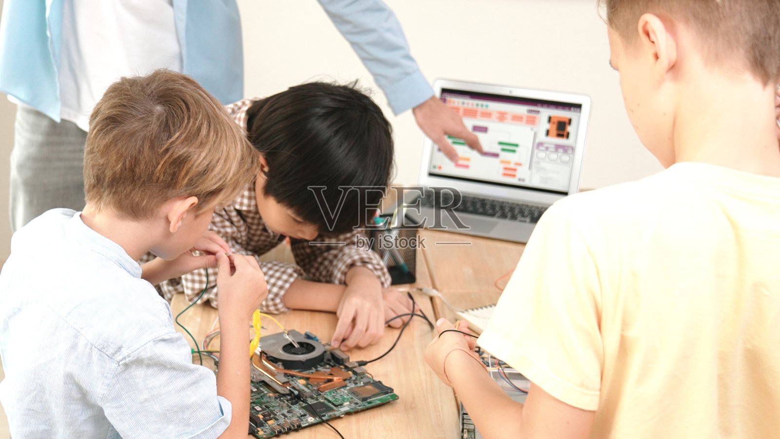 一群多元化的学生在一起合作，老师手持平板电脑。教学法。照片摄影图片