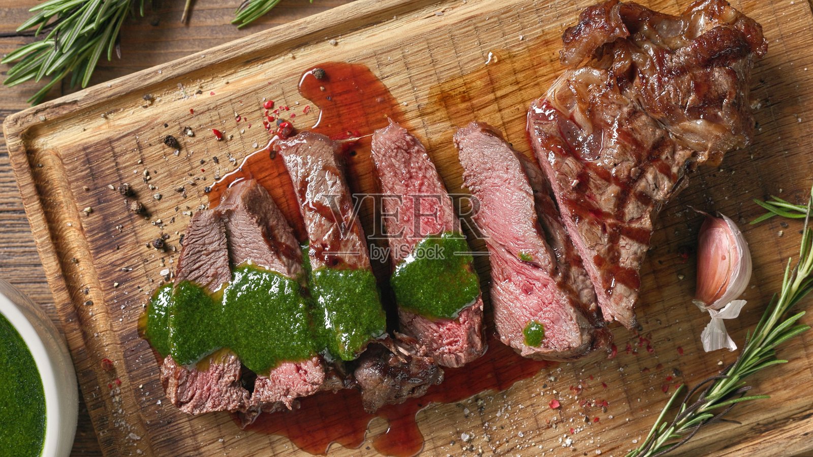 新鲜烤制的切片牛排配绿色香菜酱照片摄影图片