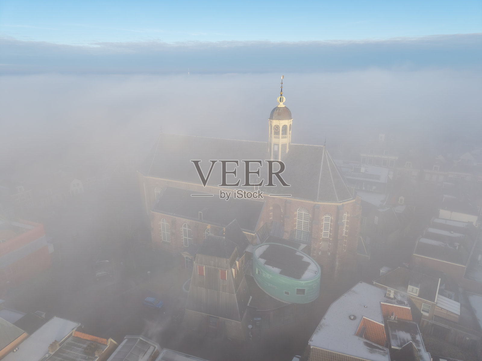 日出时教堂尖塔周围的漂浮雾气照片摄影图片