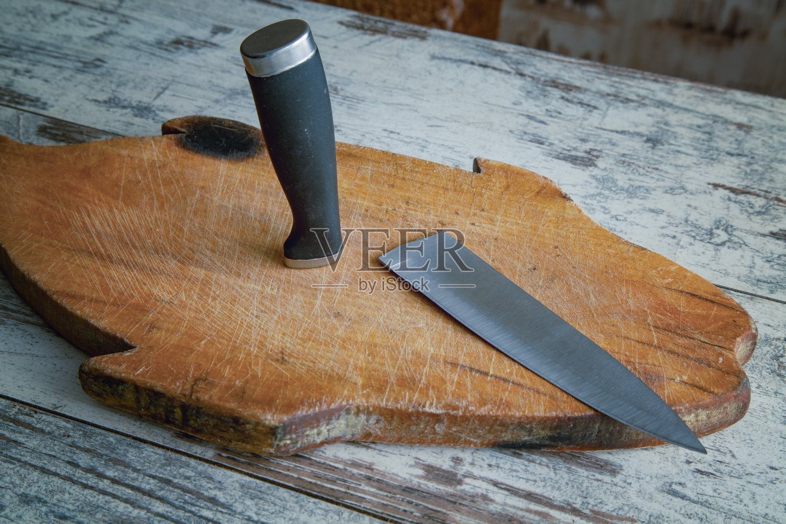 一把便宜的仿冒昂贵刀具在厨房桌上烹饪时无法承受负荷而断裂，特写展示了物品的磨损和疲劳。照片摄影图片