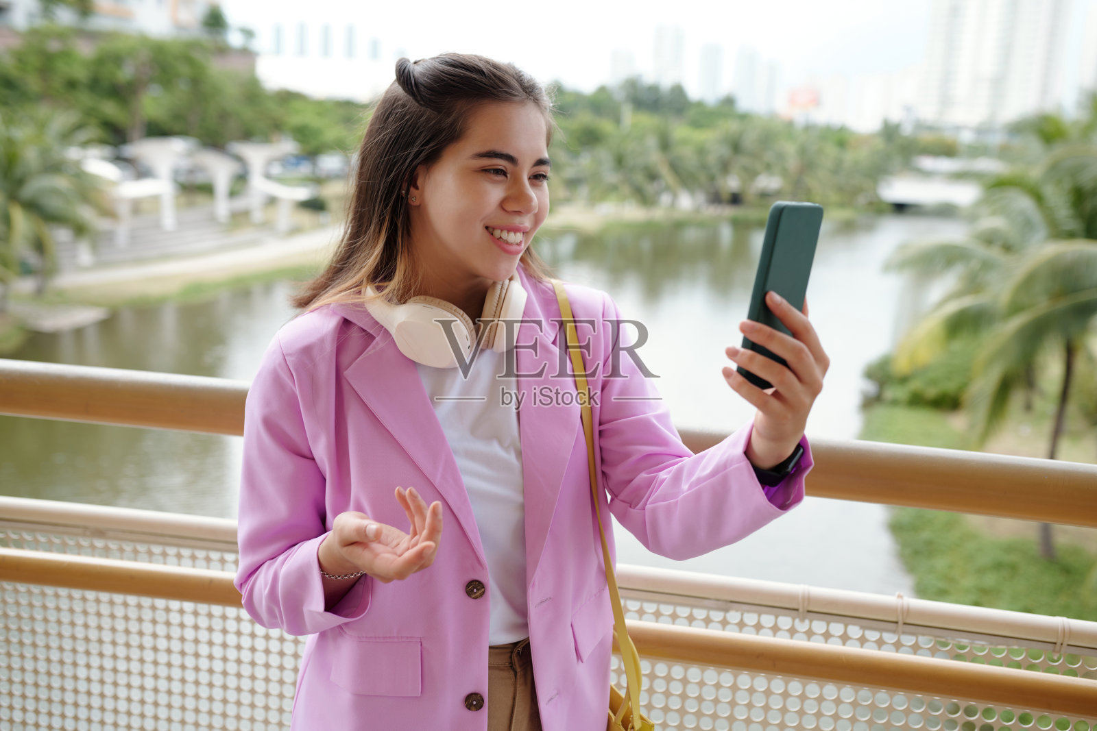 户外微笑的女性使用智能手机照片摄影图片