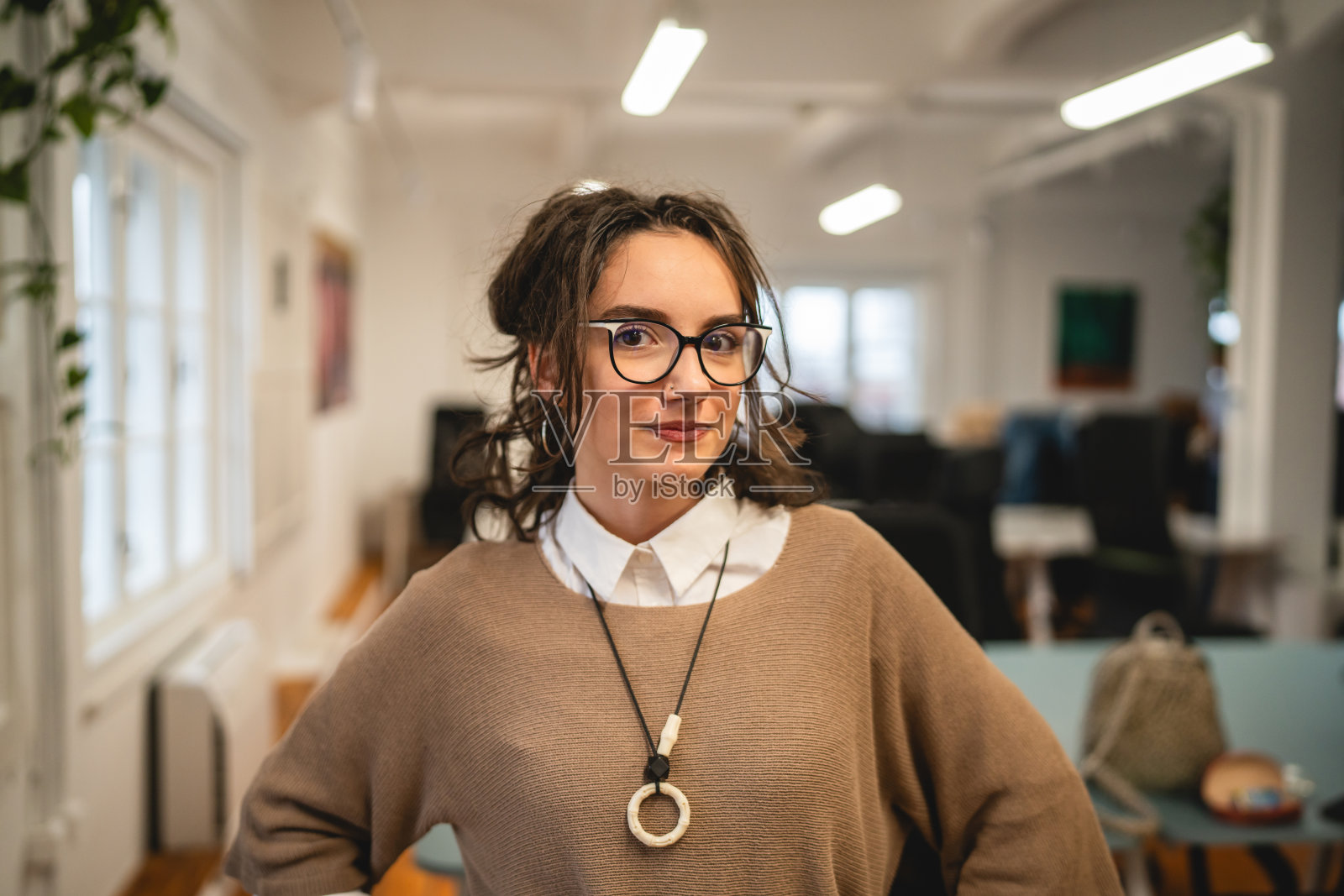 美丽的女商人在办公室微笑着站立的肖像照片摄影图片