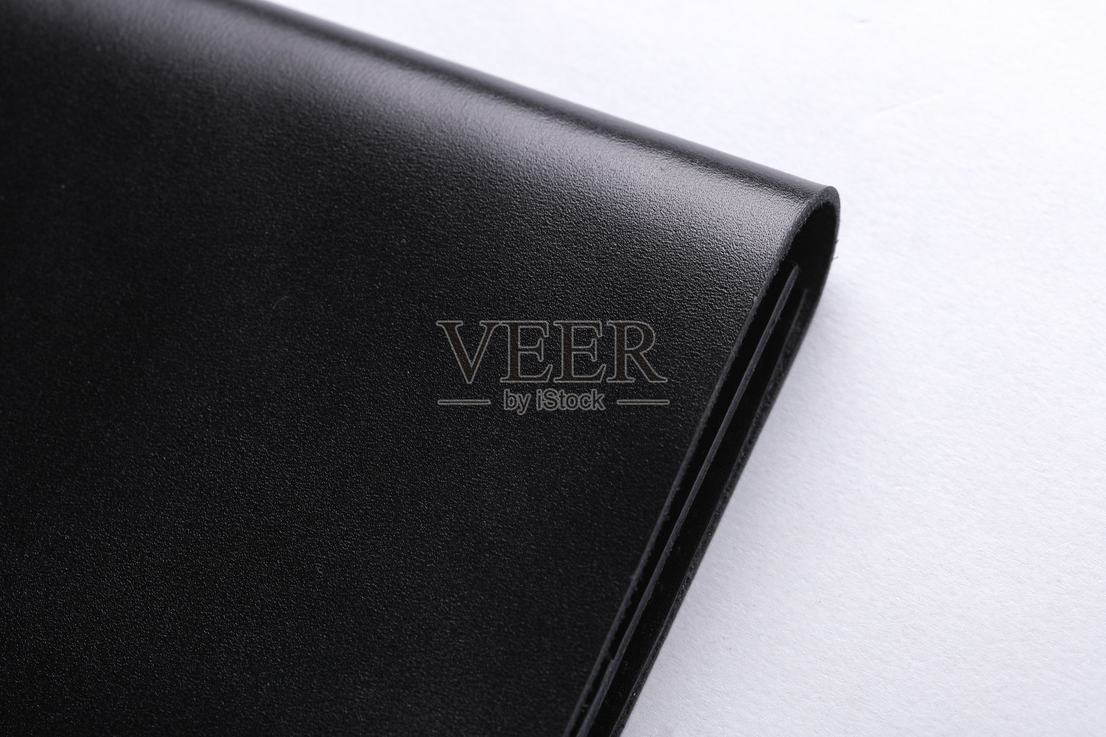 黑色皮革钱包的特写片段，背景为白色照片摄影图片