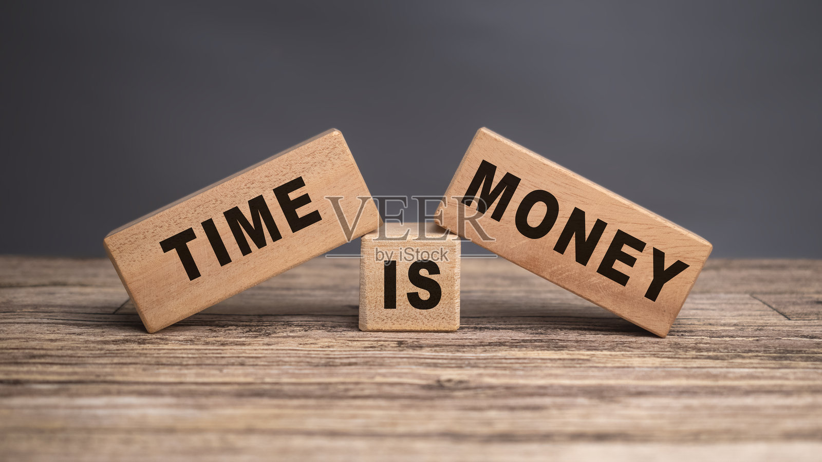 时间就是金钱，文字印在灰色背景上的木块上照片摄影图片