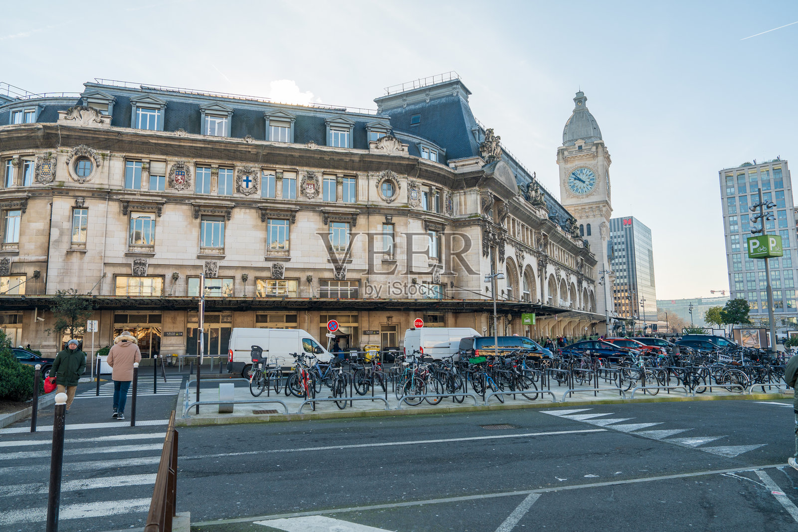 历史悠久的火车站，繁忙的自行车停车场和现代天际线背景照片摄影图片