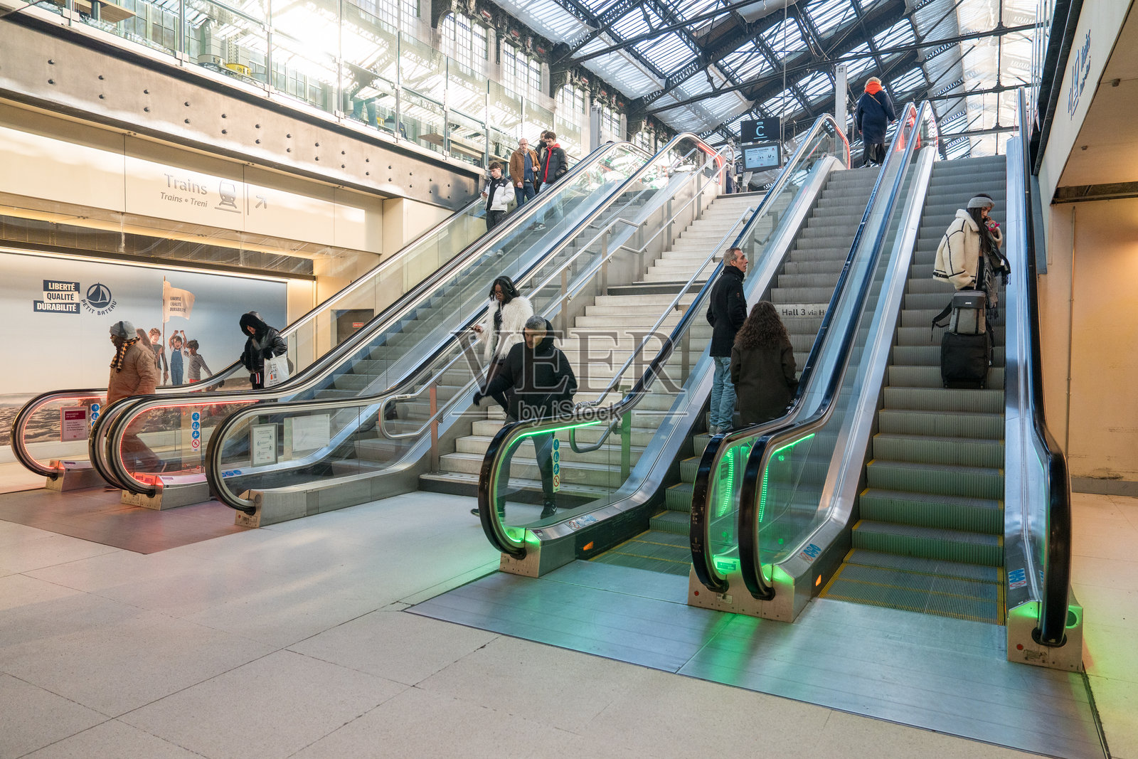 繁忙的自动扶梯上，白天的现代交通枢纽中挤满了通勤者照片摄影图片