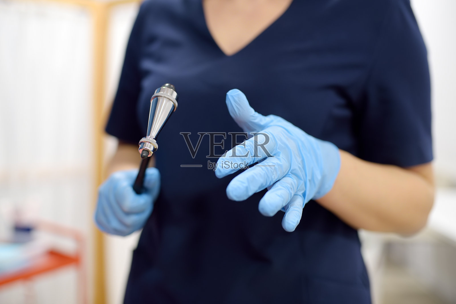 医生正在用锤子检查病人的神经反射。神经科专业医生在工作中。照片摄影图片