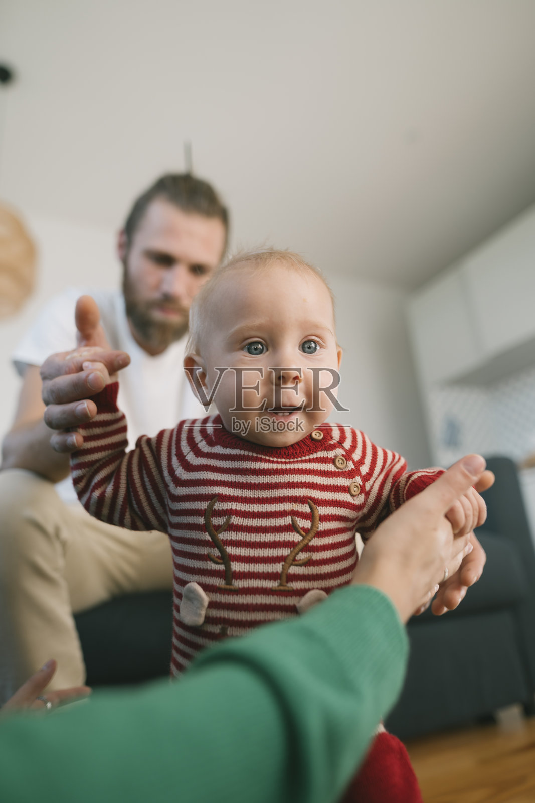 一个快乐的宝宝在温馨的家中，在关爱的父母支持下学习走路照片摄影图片