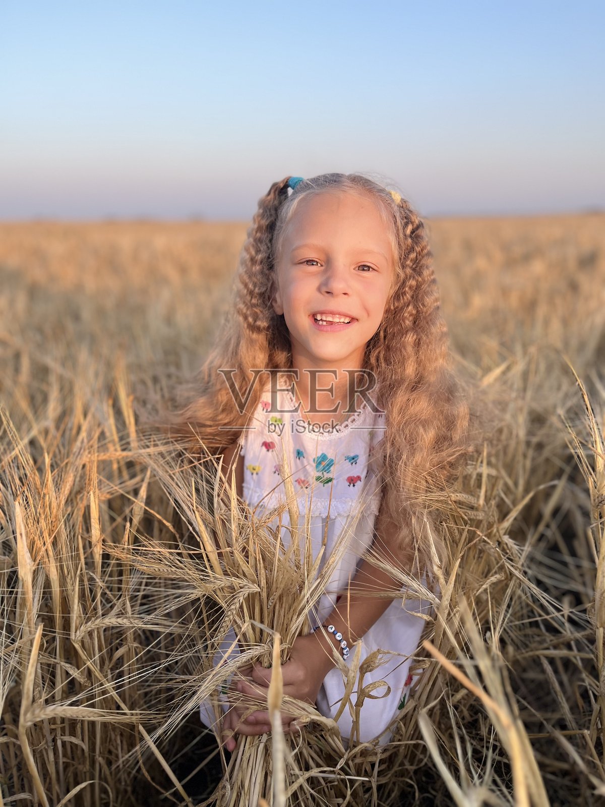 微笑女孩在天空下的田野上站立的肖像照片摄影图片