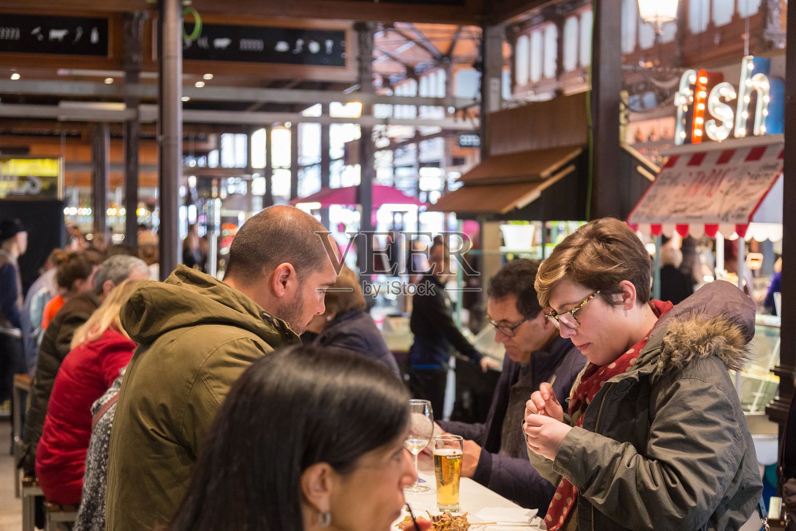 人们在马德里的圣米格尔市场饮食。照片摄影图片