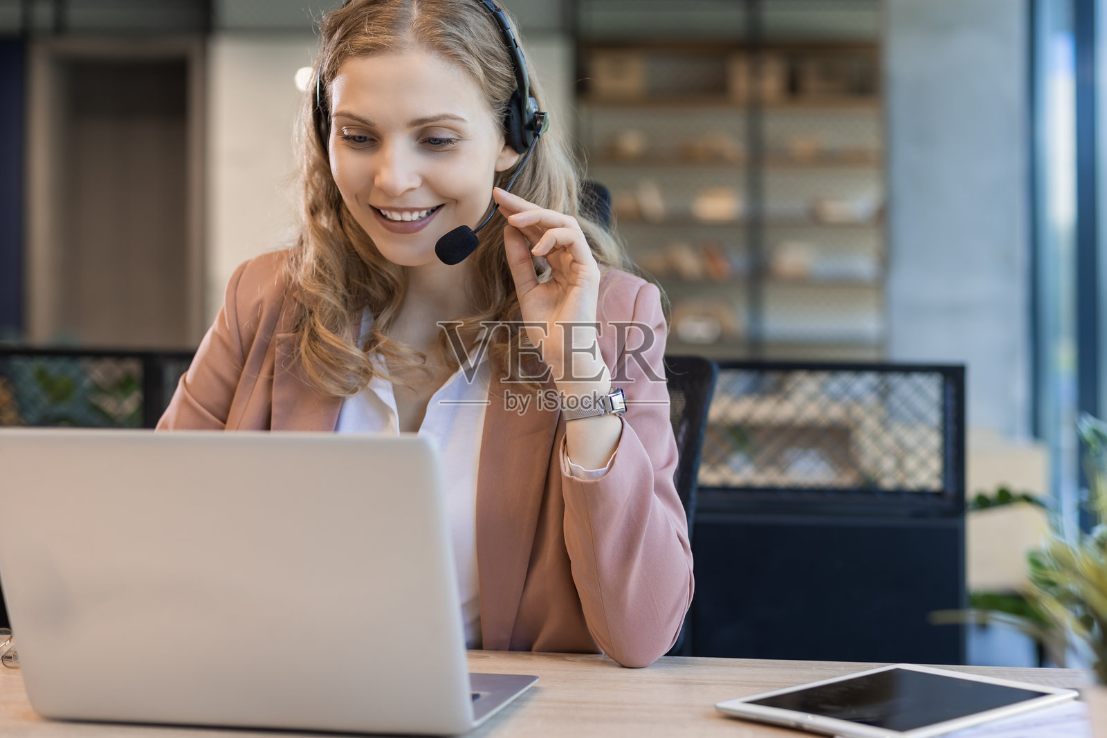 美丽微笑的呼叫中心工作人员戴着耳机在现代办公室工作照片摄影图片