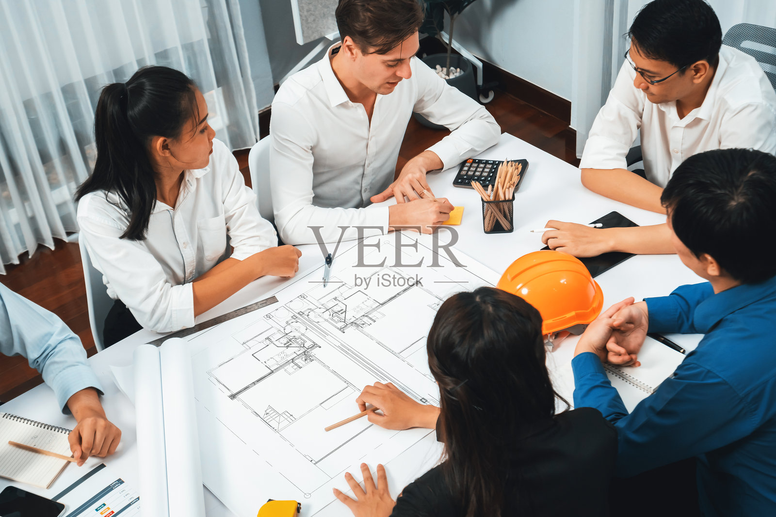 多元化的土木工程师和客户在进行建筑设计工作。谨慎。照片摄影图片