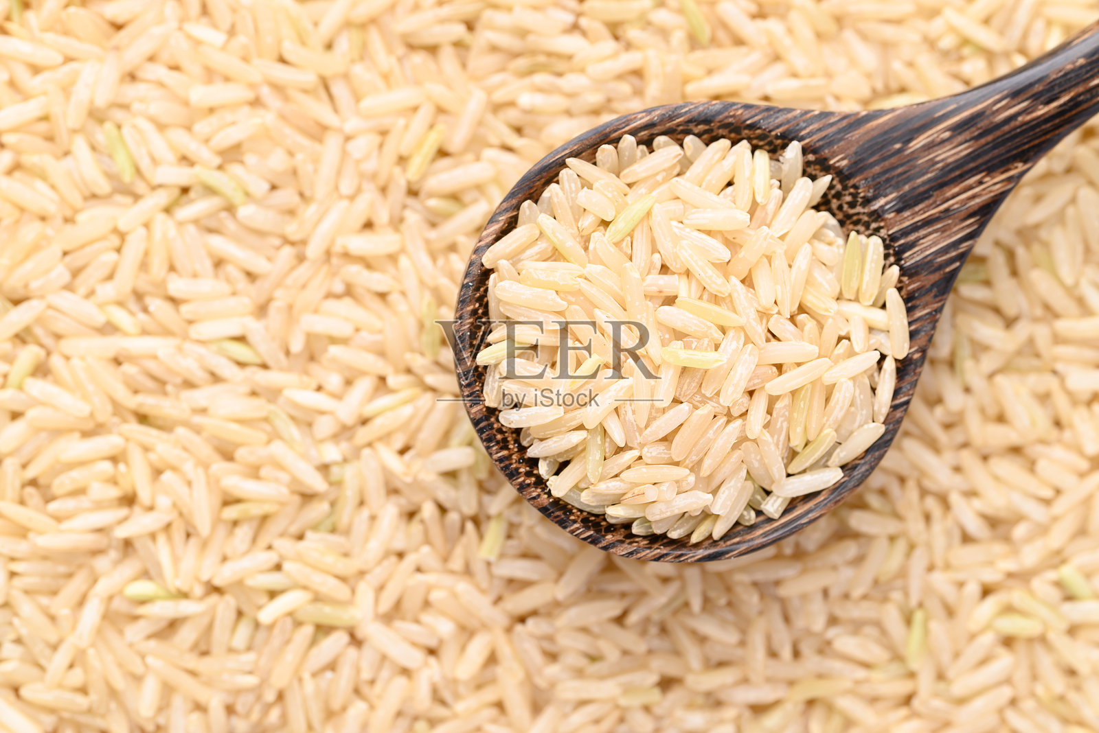 有机茉莉花棕米种子在木勺中，泰国米照片摄影图片