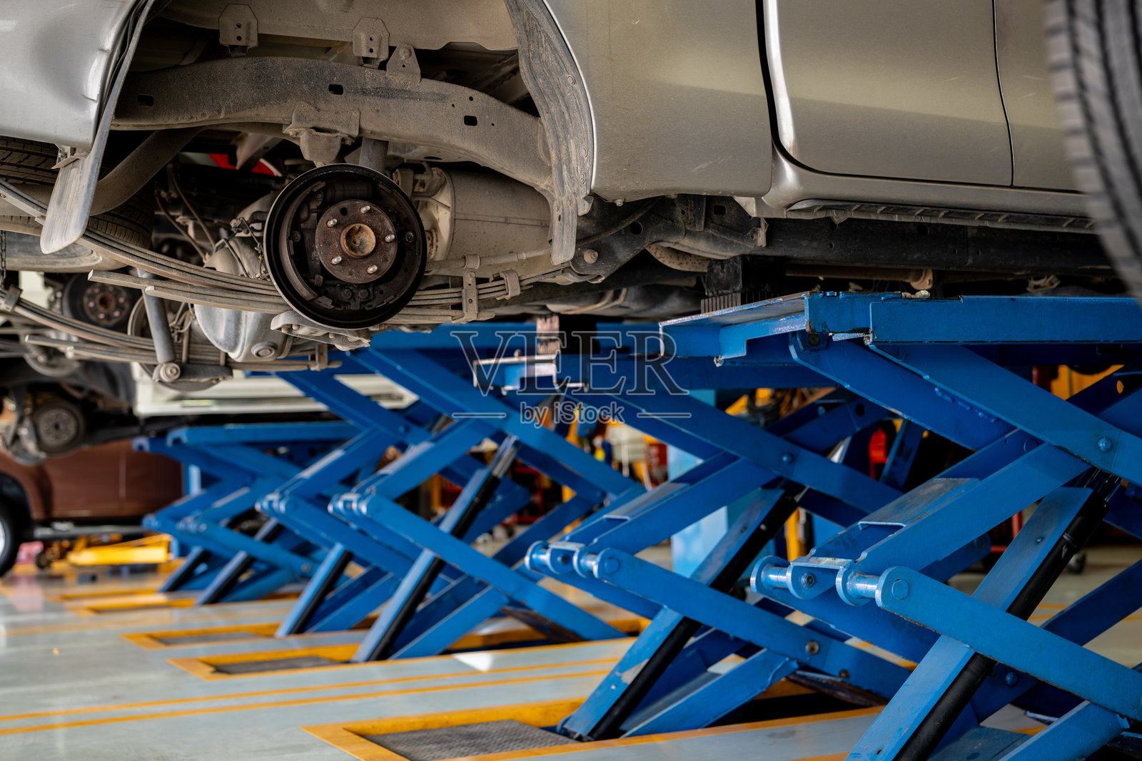 汽车维修车间更换轮胎时的刹车盘系统和悬挂维护。汽车修理和专业机械服务，确保车辆安全和性能优化。照片摄影图片