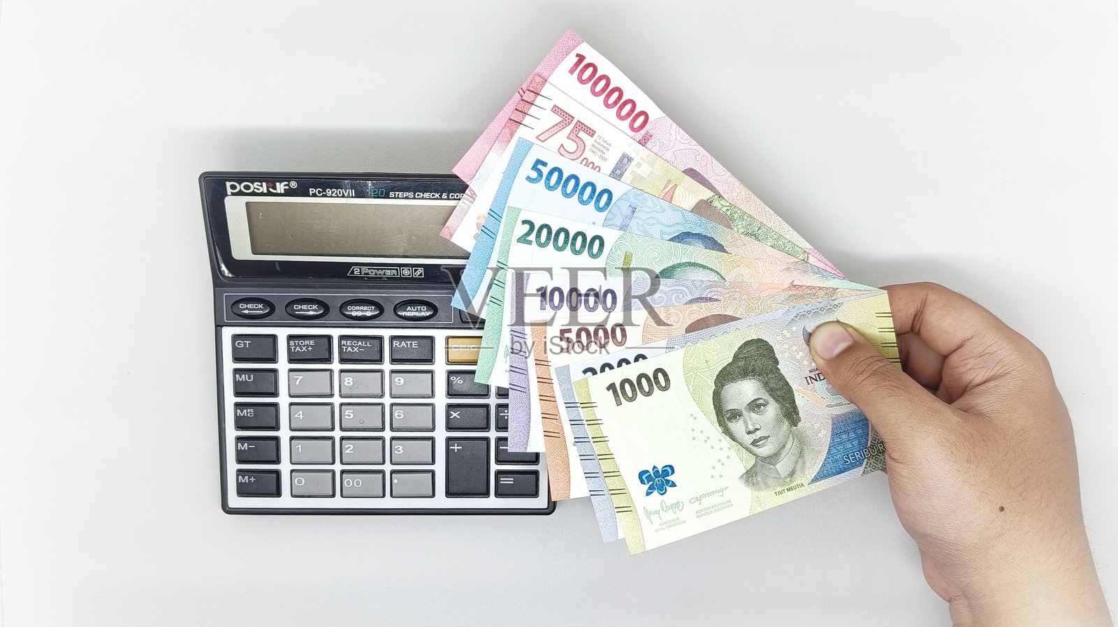 印尼的计算器和钞票。包含1000、2000、5000、10000、20000、50000、75000和100000印尼卢比的纸币收藏。照片摄影图片