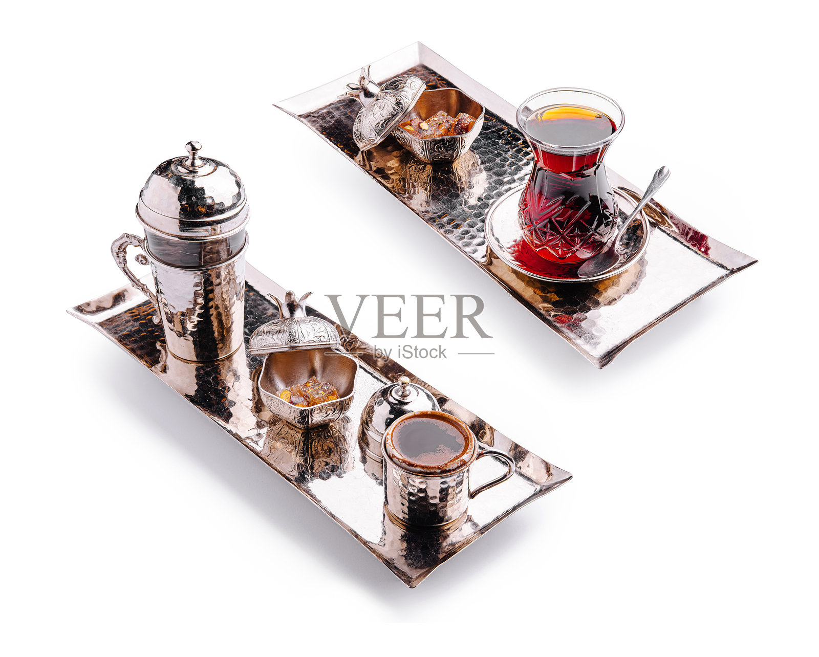 在华丽的托盘上供应的传统土耳其茶，旁边有装饰性碗中的小甜点照片摄影图片