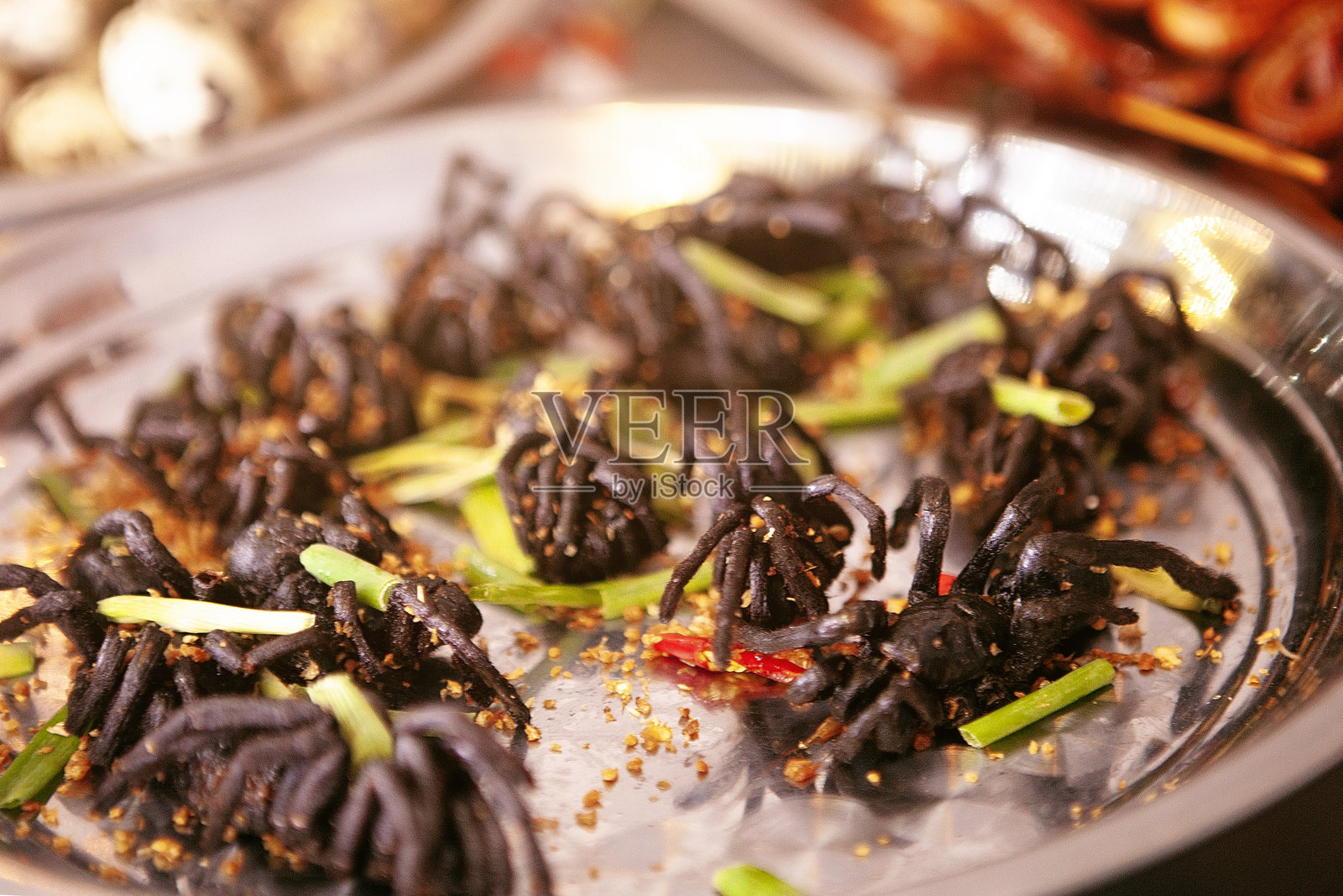 异国风味的街头小吃：柜台上的狼蛛。照片摄影图片