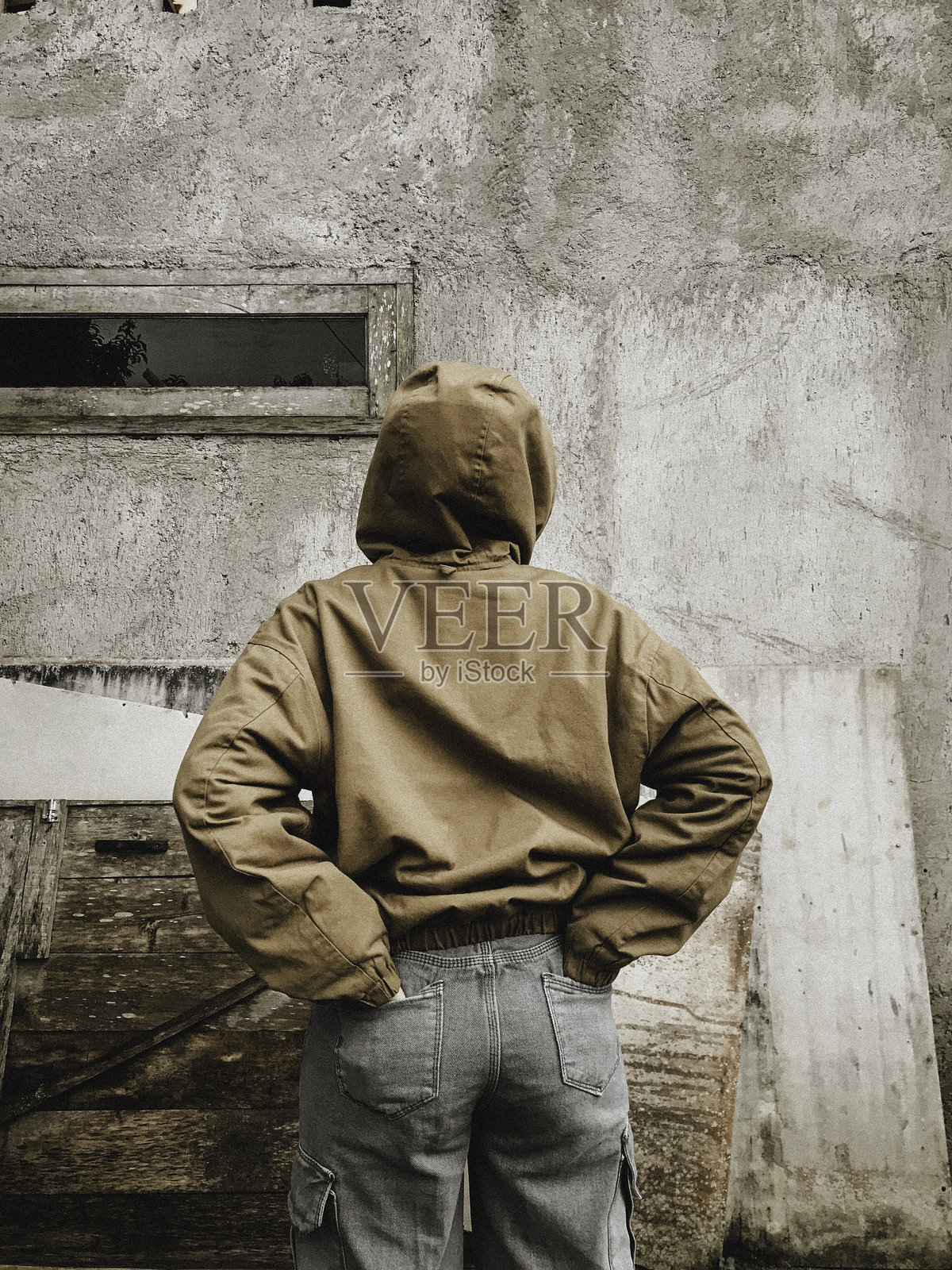 女孩背对墙壁站立的侧面视图照片摄影图片