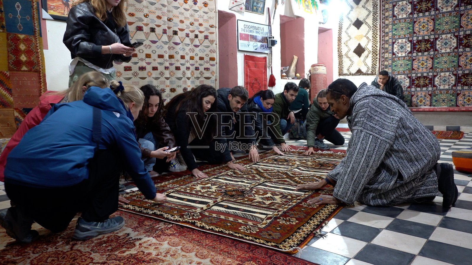 摩洛哥，达德斯德拉谷，图阿雷格柏柏尔女性通过梳理羊毛制作线材，用于地毯和织物的修剪，传统摩洛哥制造艺术。照片摄影图片