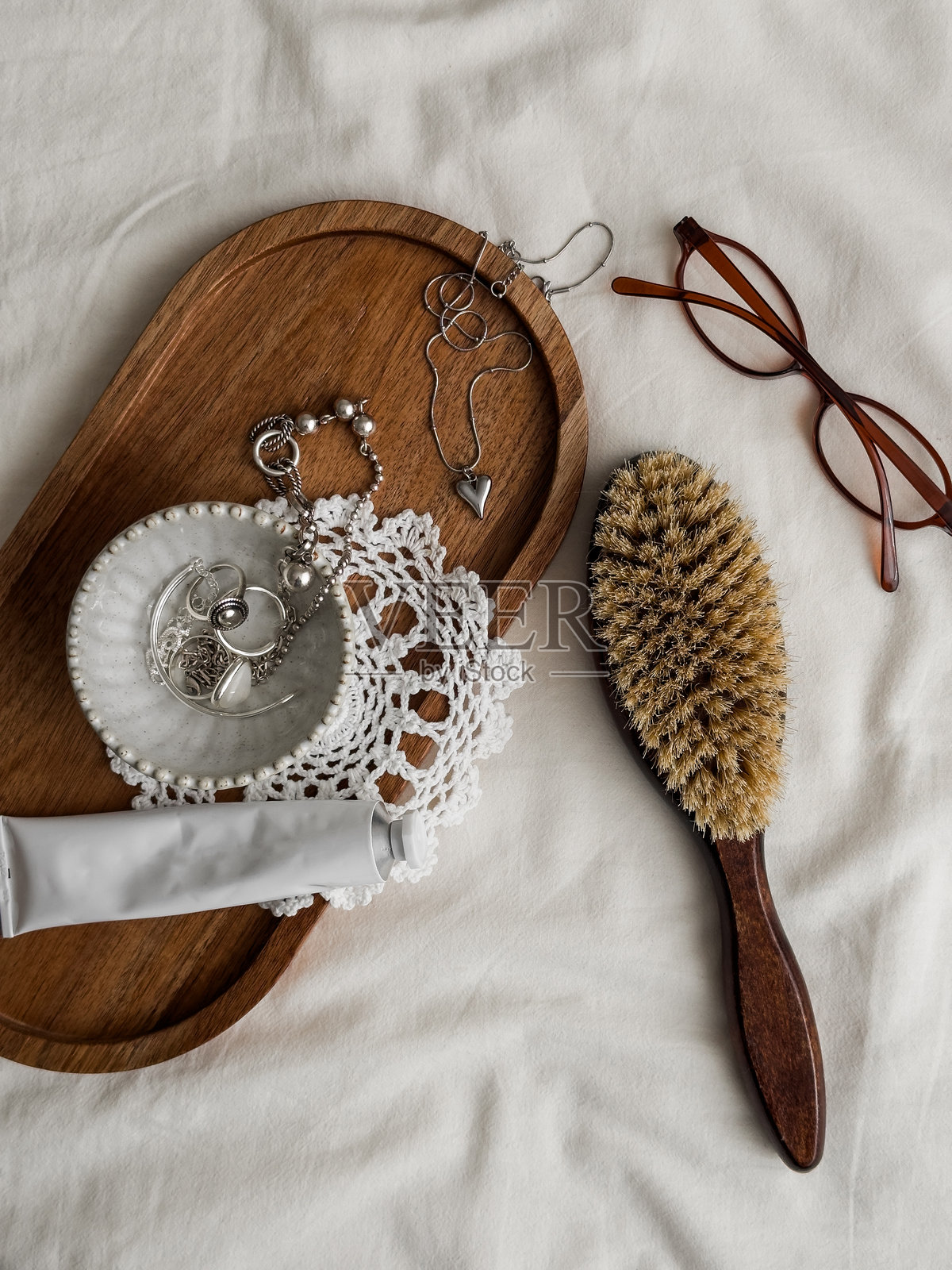 女性的美学配饰 - 梳子、化妆品、珠宝、眼镜在浅色背景上的俯视图照片摄影图片