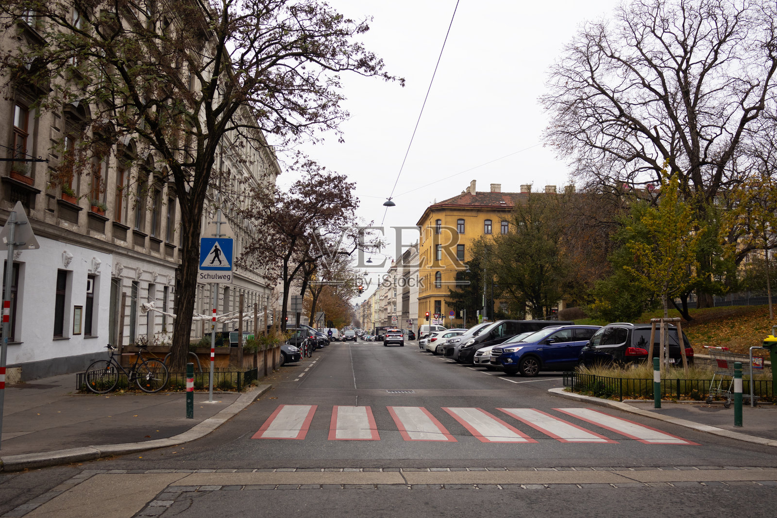一条城市街道，有人行横道、房屋和汽车照片摄影图片