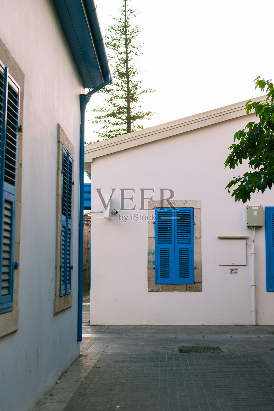 塞浦路斯帕福斯老城中，传统帕福斯房屋旁的街道，蓝色窗户百叶窗的地中海风格。照片摄影图片