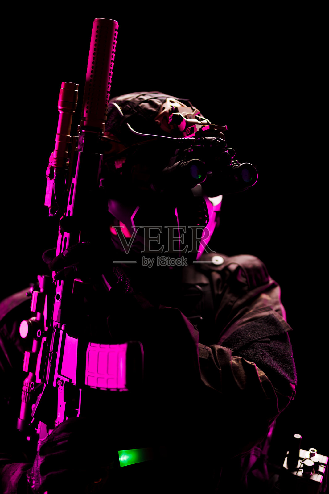 现代战术士兵配备先进装备，置身于戏剧性的灯光下照片摄影图片