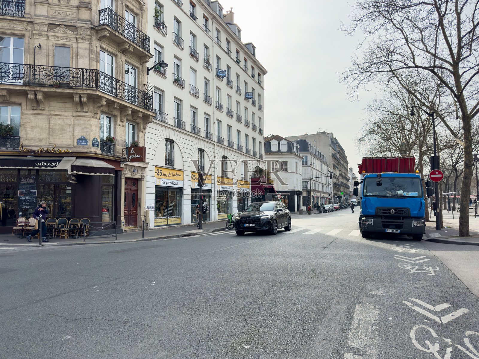 繁忙的巴黎街道,阳光下迷人的咖啡馆和经过的车辆照片摄影图片